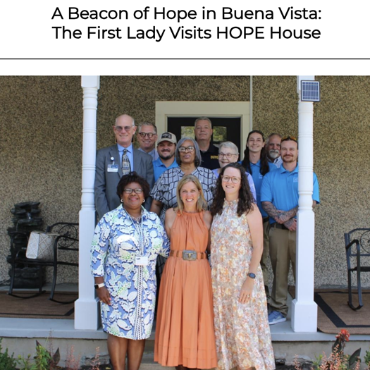 First Lady na may grupong nakatayo sa harap ng HOPE House